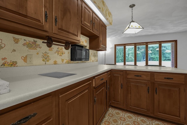 363 Carroll Eastern Rd NW, Baltimore, OH 43105 - kitchen featuring light countertops, decorative light fixtures, brown cabinetry, and a peninsula