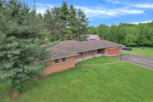 363 Carroll Eastern Rd NW, Baltimore, OH 43105 - ranch-style home featuring a garage, brick siding, asphalt driveway, a wooded view, and a shingled roof