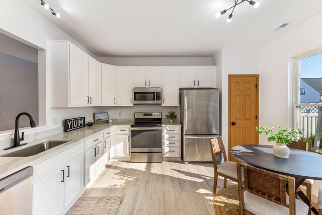 6641 Steen St, Canal Winchester, OH 43110 - kitchen with stainless steel appliances, light wood-style floors, light countertops, and white cabinets