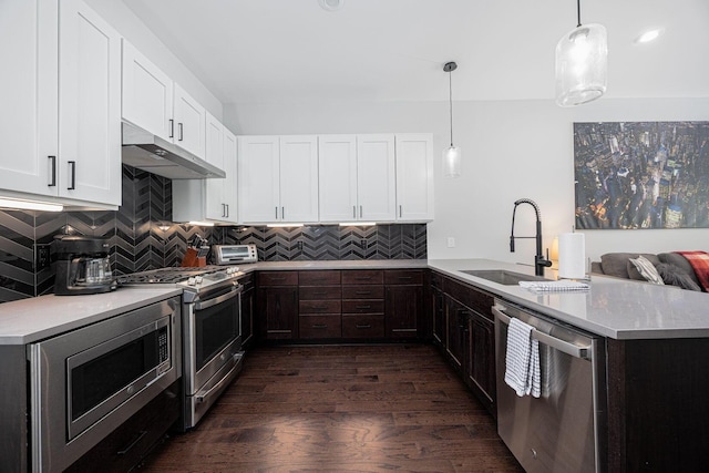 199 E 5th Ave, Columbus, OH 43201 - kitchen featuring stainless steel appliances, a sink, under cabinet range hood, a peninsula, and light countertops