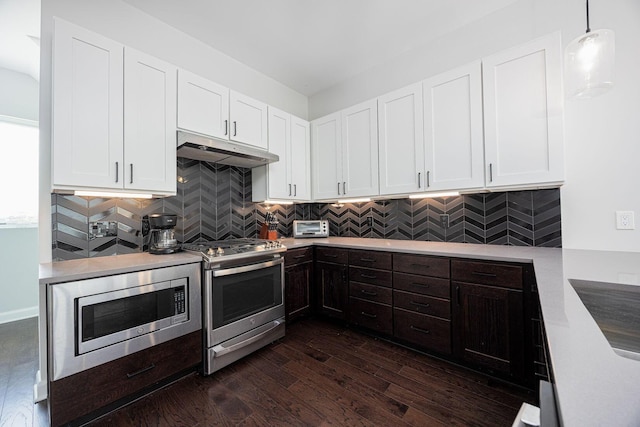 199 E 5th Ave, Columbus, OH 43201 - kitchen with stainless steel appliances, under cabinet range hood, light countertops, dark wood-type flooring, and white cabinets