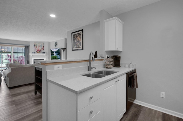 4057 Blendon Point Dr Unit 60A, Columbus, OH 43230 - kitchen featuring a sink, a textured ceiling, dark wood finished floors, white cabinetry, and a fireplace