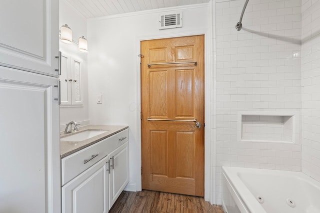 11007 Hebron Rd, Buckeye Lake, OH 43008 - bathroom featuring vanity, wood finished floors, and a combined bath / shower with jetted tub