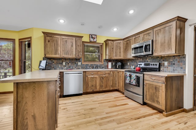 3753 Homer Rd NW, Utica, OH 43080 - kitchen with appliances with stainless steel finishes, a peninsula, light wood-style flooring, backsplash, and a sink