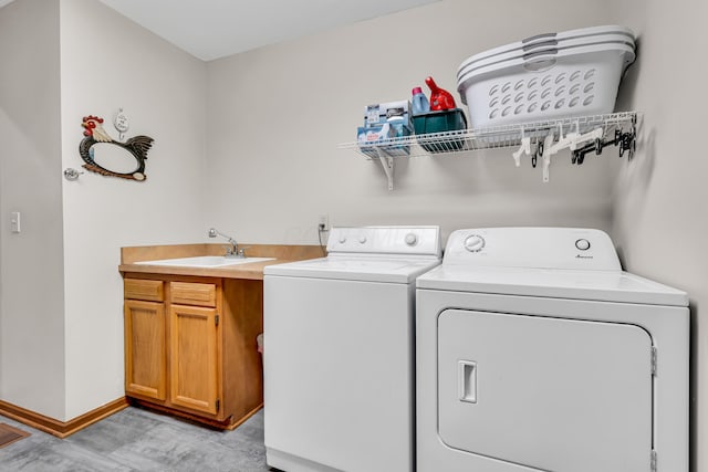 3753 Homer Rd NW, Utica, OH 43080 - laundry room featuring washer and clothes dryer, baseboards, light wood-type flooring, and cabinet space