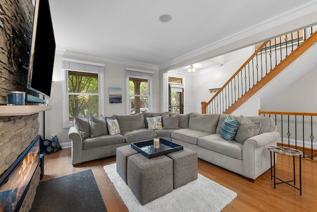 1054 Perry St, Columbus, OH 43201 - living room featuring crown molding, wood finished floors, a fireplace, stairs, and baseboards