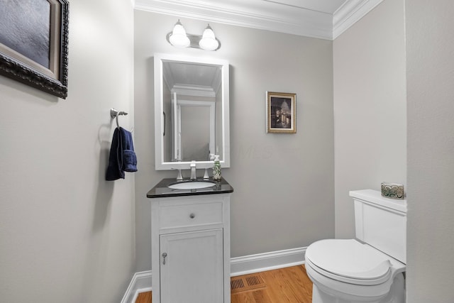 1054 Perry St, Columbus, OH 43201 - half bathroom with wood finished floors, ornamental molding, baseboards, vanity, and toilet