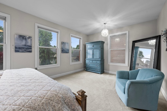 1054 Perry St, Columbus, OH 43201 - bedroom featuring baseboards, light carpet, and a chandelier