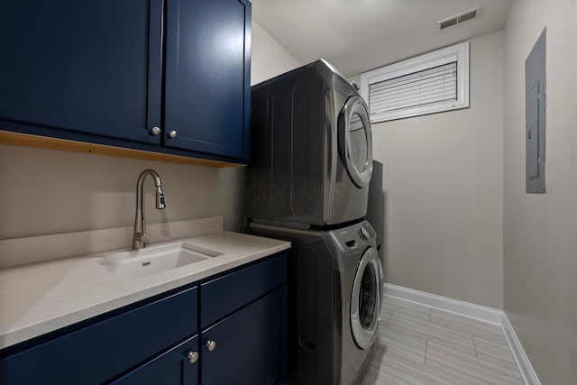 1054 Perry St, Columbus, OH 43201 - washroom featuring stacked washer and clothes dryer, cabinet space, baseboards, and electric panel