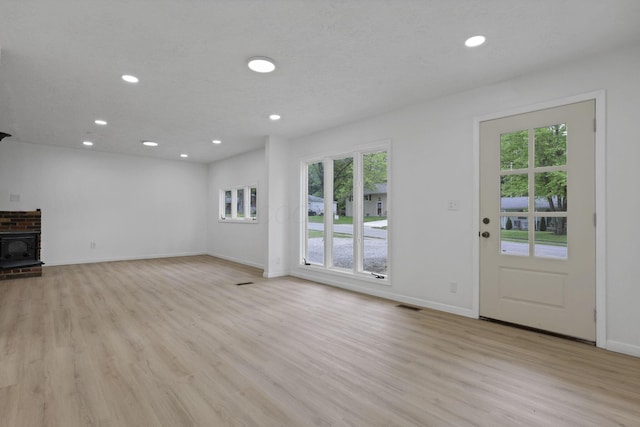 366 Orchard Ln, Sunbury, OH 43074 - unfurnished living room with a wood stove, recessed lighting, light wood-style floors, and baseboards