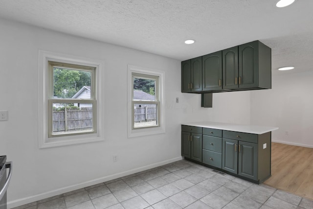 366 Orchard Ln, Sunbury, OH 43074 - kitchen with a textured ceiling, green cabinetry, light countertops, baseboards, and recessed lighting