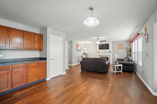 218 Christian St, Delaware, OH 43015 - kitchen featuring brown cabinets, dark wood finished floors, a fireplace, a ceiling fan, and open floor plan