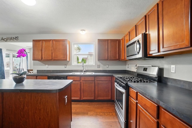 218 Christian St, Delaware, OH 43015 - kitchen with stainless steel appliances, a sink, dark countertops, healthy amount of natural light, and a textured ceiling