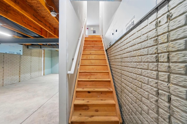 218 Christian St, Delaware, OH 43015 - staircase with brick wall and concrete flooring