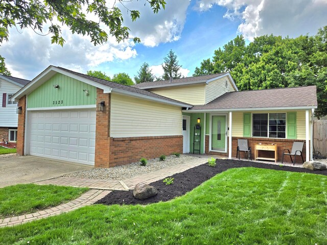 3523 Meldrake St, Columbus, OH 43230 - split level home featuring brick siding, a garage, a porch, and concrete driveway