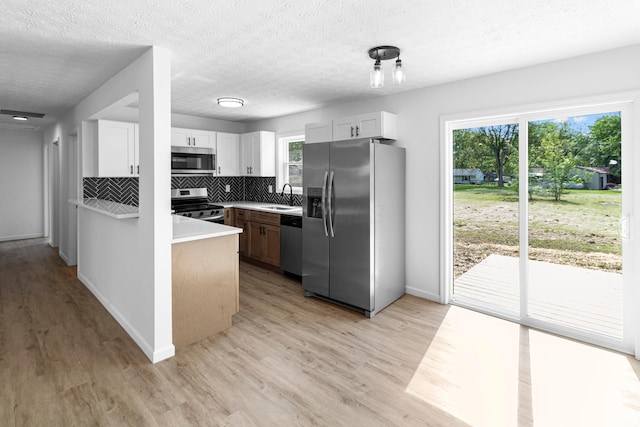 70 5th Ave SW, Etna, OH 43062 - kitchen with appliances with stainless steel finishes, a sink, tasteful backsplash, light countertops, and light wood-type flooring