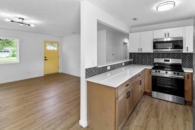 70 5th Ave SW, Etna, OH 43062 - kitchen with stainless steel appliances, light wood finished floors, light countertops, and a textured ceiling