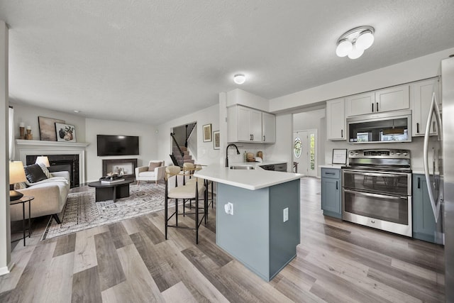 1779 Westwood Dr, Lewis Center, OH 43035 - kitchen with range with two ovens, a sink, a textured ceiling, open floor plan, and a peninsula