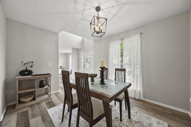 1779 Westwood Dr, Lewis Center, OH 43035 - dining room with wood finished floors, a chandelier, baseboards, and a textured ceiling