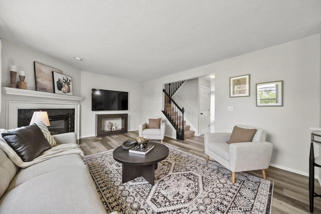 1779 Westwood Dr, Lewis Center, OH 43035 - living room featuring stairs, a premium fireplace, wood finished floors, baseboards, and a textured ceiling