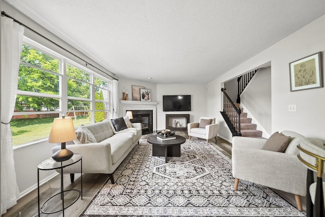 1779 Westwood Dr, Lewis Center, OH 43035 - living area with a textured ceiling, wood finished floors, a premium fireplace, stairway, and baseboards