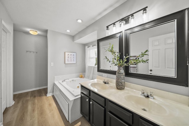 1779 Westwood Dr, Lewis Center, OH 43035 - full bath with a tub with jets, double vanity, wood finished floors, and recessed lighting