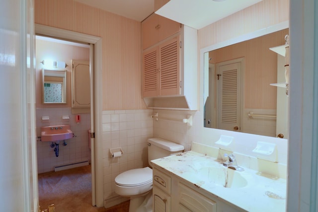 1602 Pleasantview Dr, Lancaster, OH 43130 - bathroom featuring wallpapered walls, a baseboard heating unit, a sink, toilet, and tile walls