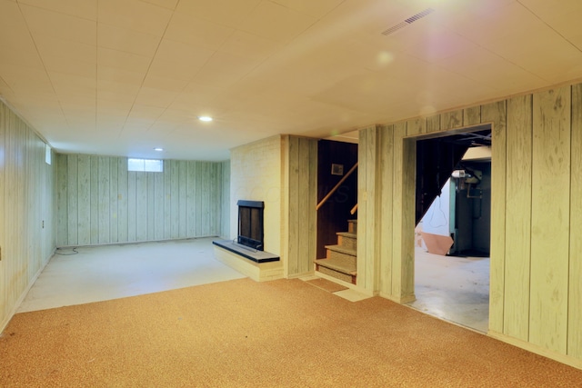 1602 Pleasantview Dr, Lancaster, OH 43130 - below grade area featuring wooden walls, stairs, a fireplace, and carpet
