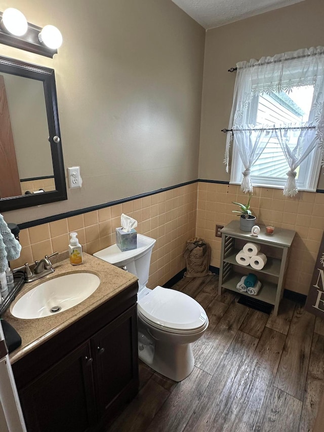 4902 Columbus Sandusky Rd N, Marion, OH 43302 - bathroom with tile walls, toilet, vanity, wood finished floors, and a wainscoted wall