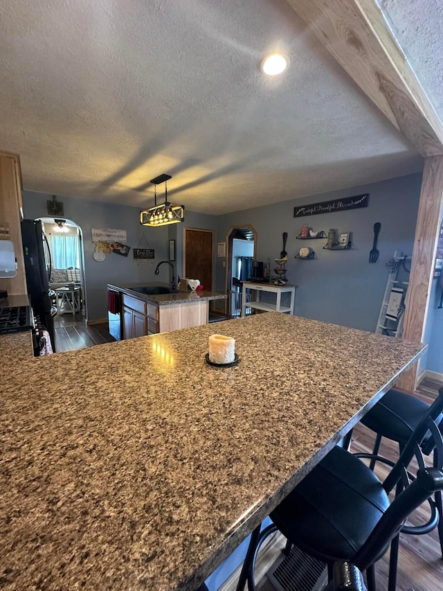 4902 Columbus Sandusky Rd N, Marion, OH 43302 - kitchen featuring a sink, a textured ceiling, a center island with sink, baseboards, and dark wood-style floors