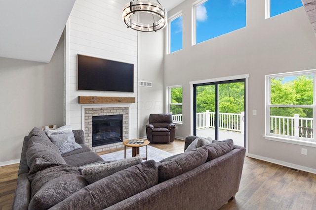 3000 State Route 257, Radnor, OH 43066 - living room with wood finished floors, a high ceiling, a chandelier, a fireplace, and baseboards
