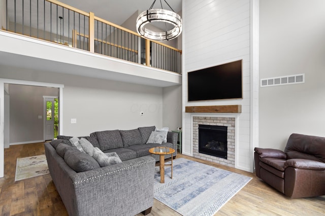 3000 State Route 257, Radnor, OH 43066 - living area featuring a towering ceiling, wood finished floors, a fireplace, and a chandelier