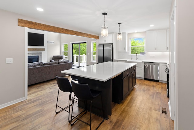 3000 State Route 257, Radnor, OH 43066 - kitchen with appliances with stainless steel finishes, light countertops, a breakfast bar area, a center island, and decorative backsplash