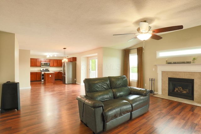 1690 Autumn Dr, Lancaster, OH 43130 - living room with dark wood finished floors, a ceiling fan, a tiled fireplace, and a textured ceiling
