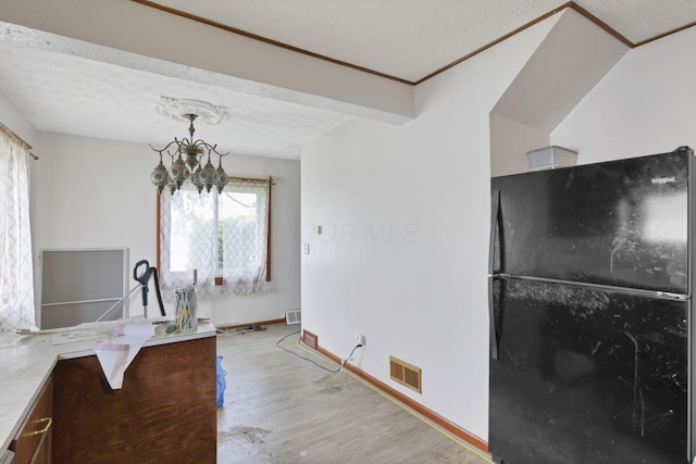4209 Avery Rd, Hilliard, OH 43026 - kitchen with freestanding refrigerator, light wood-style flooring, a chandelier, a textured ceiling, and baseboards