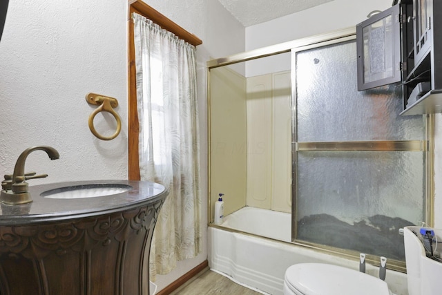 4209 Avery Rd, Hilliard, OH 43026 - full bath featuring shower / bath combination with glass door, wood finished floors, vanity, toilet, and a textured wall