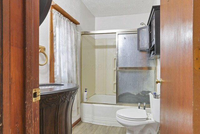 4209 Avery Rd, Hilliard, OH 43026 - full bathroom featuring toilet, wood finished floors, shower / bath combination with glass door, and a textured ceiling