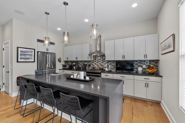 233 S Ohio Ave Unit 11, Columbus, OH 43205 - kitchen featuring appliances with stainless steel finishes, dark countertops, wall chimney exhaust hood, a sink, and backsplash