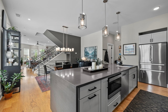233 S Ohio Ave Unit 11, Columbus, OH 43205 - kitchen with appliances with stainless steel finishes, a sink, dark countertops, light wood-style floors, and open floor plan