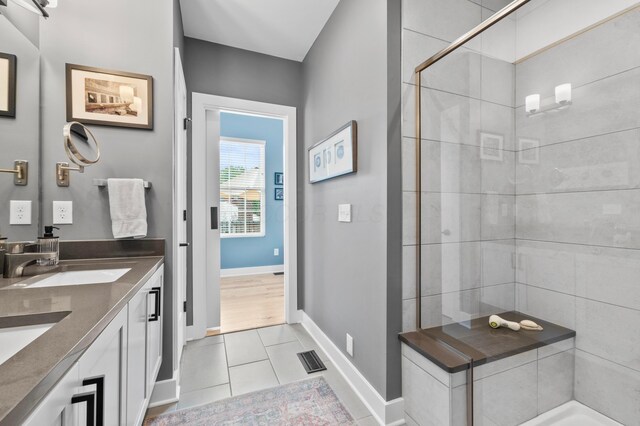 233 S Ohio Ave Unit 11, Columbus, OH 43205 - bathroom featuring double vanity, baseboards, tile patterned floors, and a tile shower