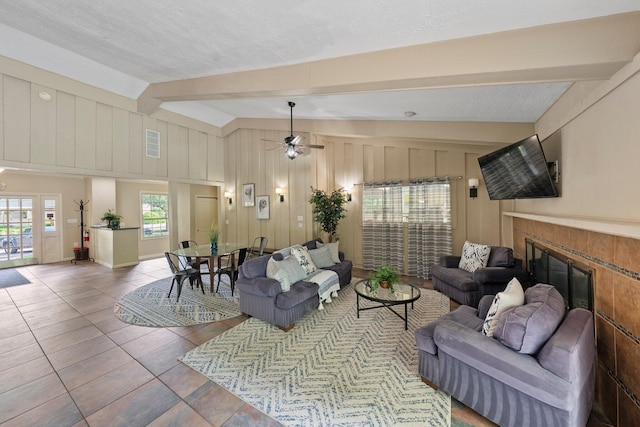 2560 Scioto View Ln, Columbus, OH 43221 - tiled living room featuring plenty of natural light, a glass covered fireplace, a ceiling fan, a textured ceiling, and wood walls