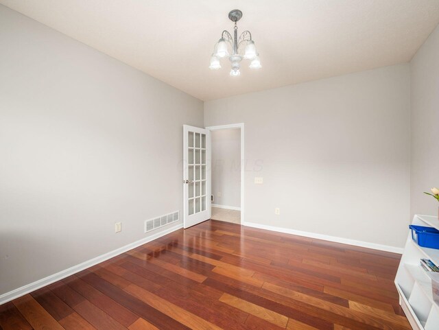 7915 Fargo Ln, Delaware, OH 43015 - unfurnished room featuring a chandelier, hardwood / wood-style floors, and baseboards