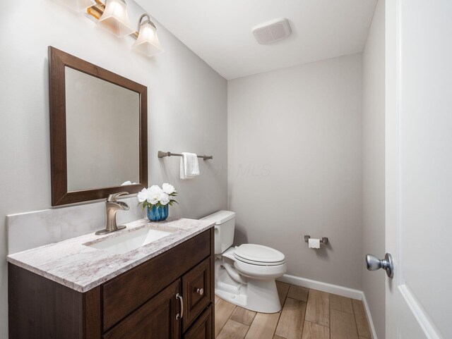 7915 Fargo Ln, Delaware, OH 43015 - half bath featuring vanity, toilet, baseboards, and wood finished floors