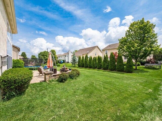 7915 Fargo Ln, Delaware, OH 43015 - view of grassy yard with a trampoline, a patio area, and a residential view