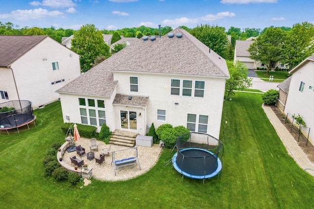7915 Fargo Ln, Delaware, OH 43015 - back of property with a trampoline, stucco siding, roof with shingles, and a lawn