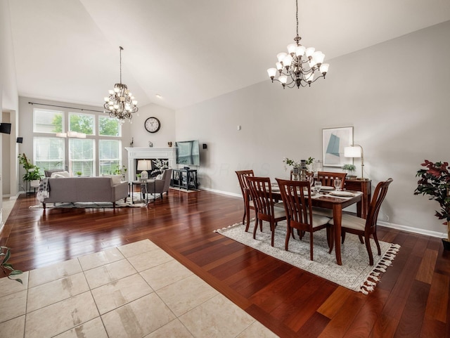 7915 Fargo Ln, Delaware, OH 43015 - dining room featuring a chandelier, a fireplace, high vaulted ceiling, and wood finished floors