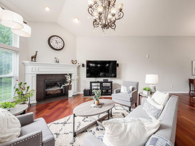 7915 Fargo Ln, Delaware, OH 43015 - living area featuring a chandelier, wood finished floors, vaulted ceiling, a tiled fireplace, and recessed lighting