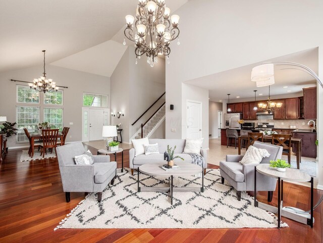 7915 Fargo Ln, Delaware, OH 43015 - living area with a chandelier, high vaulted ceiling, wood finished floors, stairway, and arched walkways