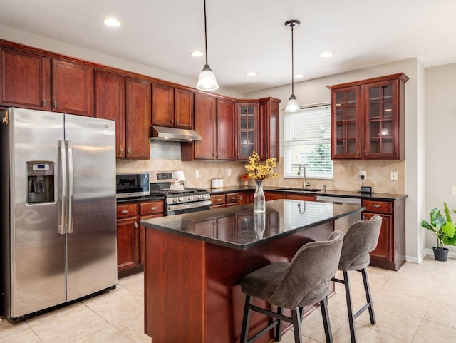 7915 Fargo Ln, Delaware, OH 43015 - kitchen featuring appliances with stainless steel finishes, under cabinet range hood, a sink, light tile patterned flooring, and tasteful backsplash