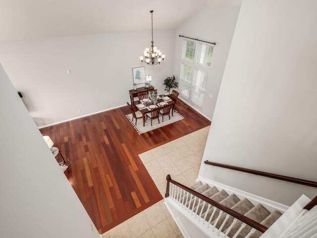 7915 Fargo Ln, Delaware, OH 43015 - staircase with a chandelier, tile patterned floors, baseboards, and high vaulted ceiling